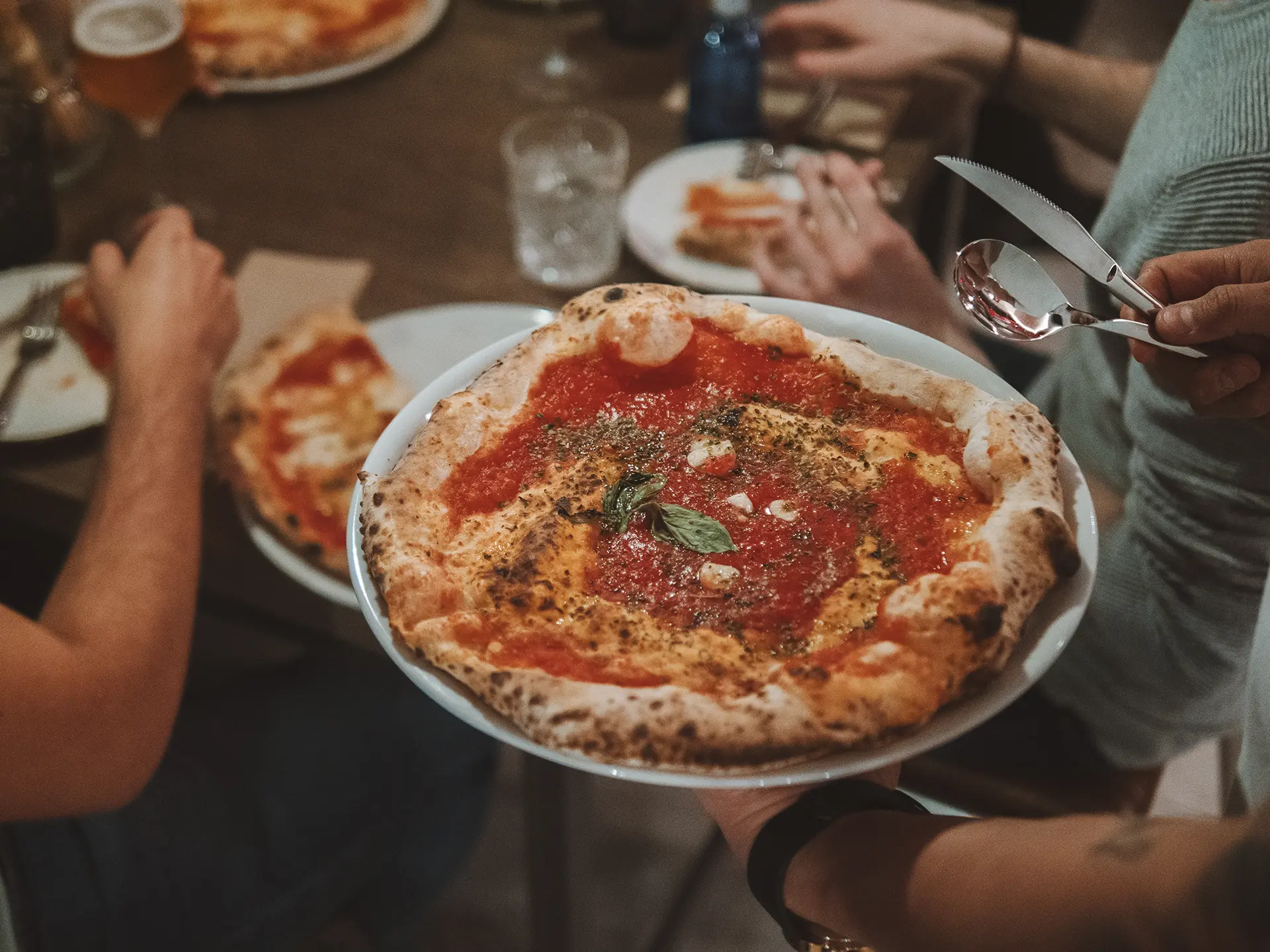 camarero sirviendo pizza napolitana